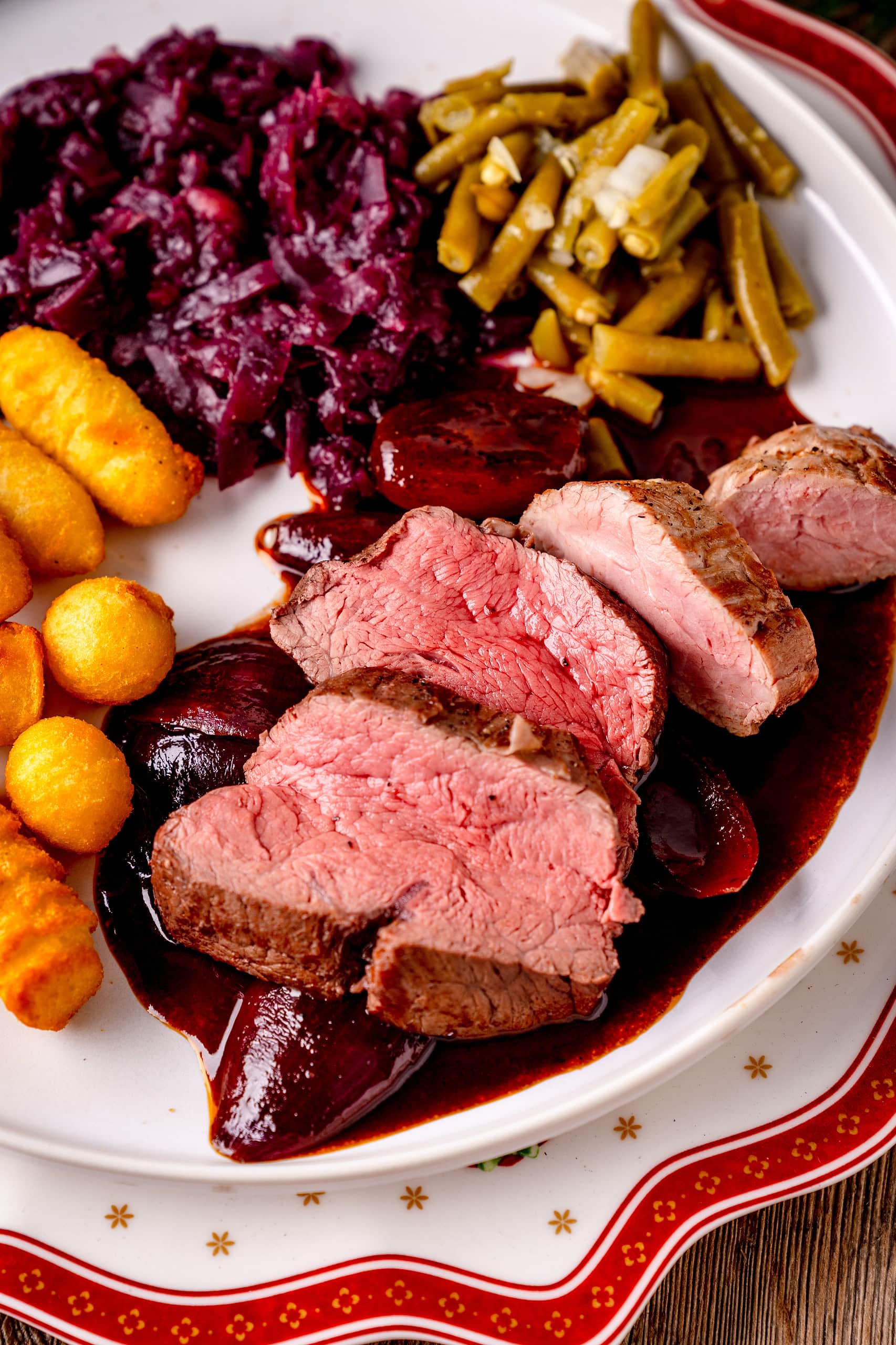 Filets in dunkler Rotweinsauce. Schweinefilet Rinderfilet Bohnensalat Weihnachten Festessen festlich Kroketten Rotkohl Bohnensalat