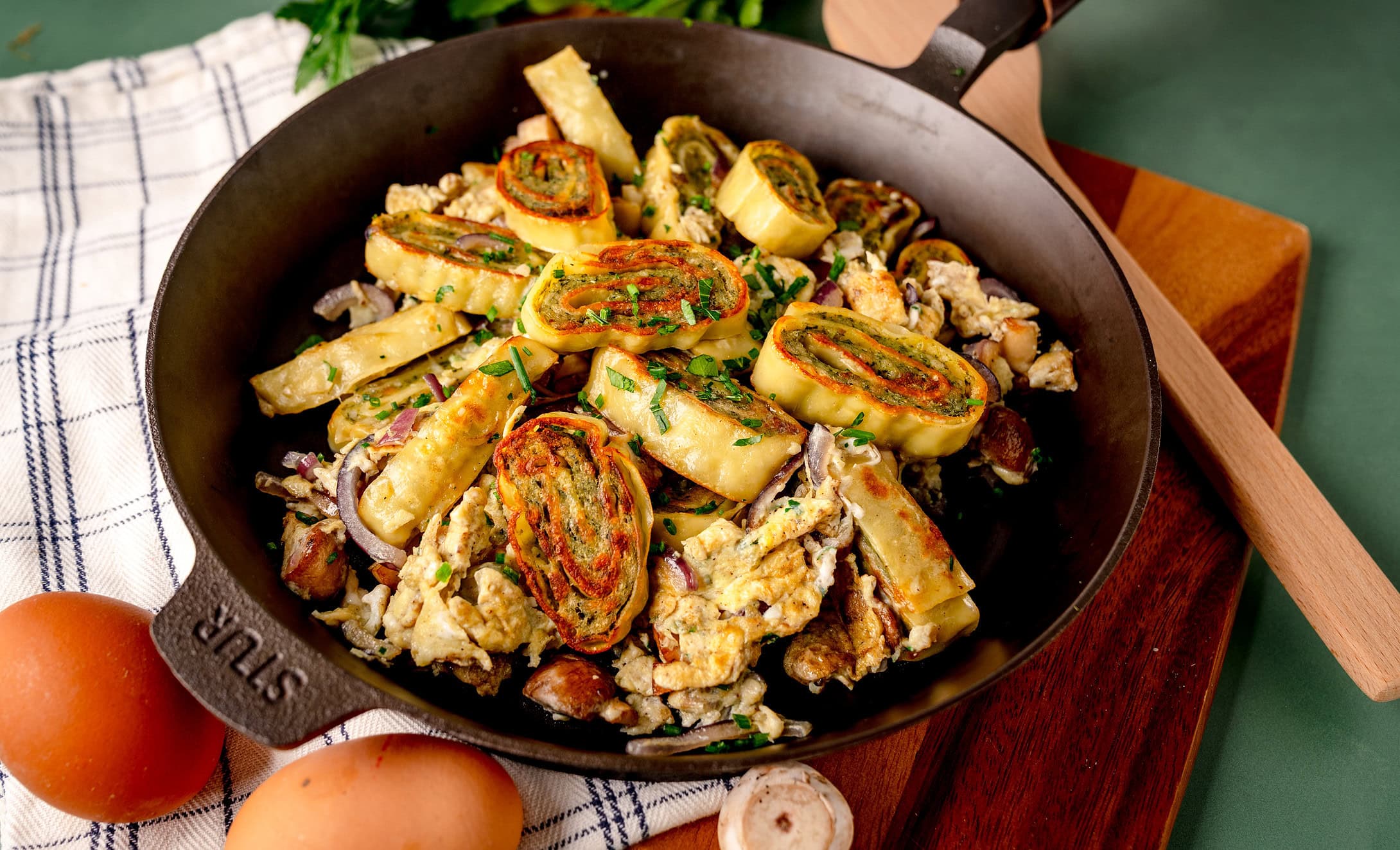 Frische schnelle Maultaschenpfanne mit Eiern und Kräutern in einer Pfanne serviert. und C