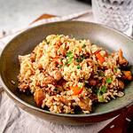 Ein schön angerichteter Teller Plov mit Hähnchen und Petersilie