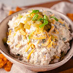 Pickle Dip saure Gurkendipp im Querformat mit geriebenem Cheddarkäse