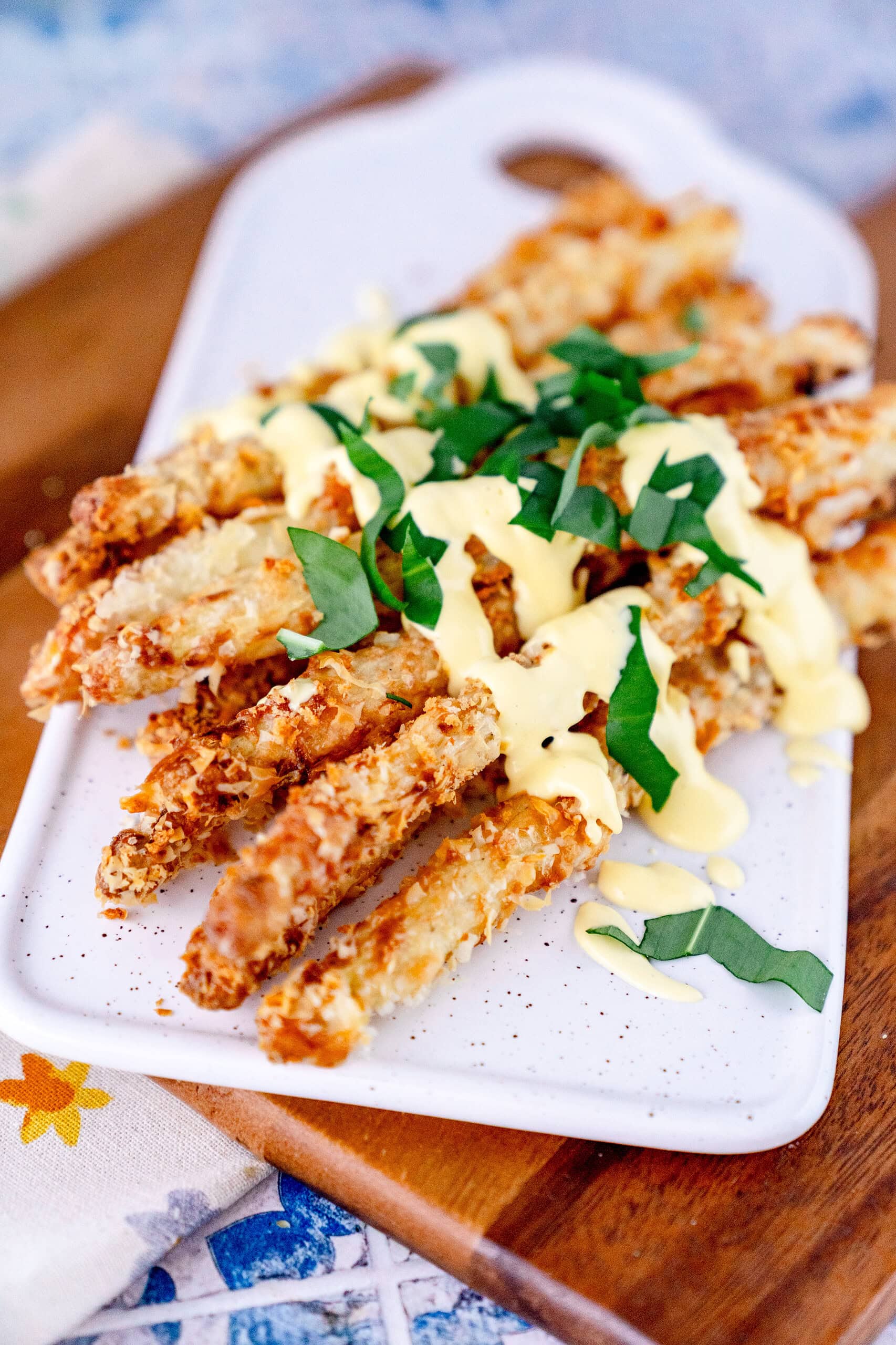 Spargel aus der Heißluftfritteuse in goldgelb gerösteten Panade mit Klecksen von gelber Hollandaise