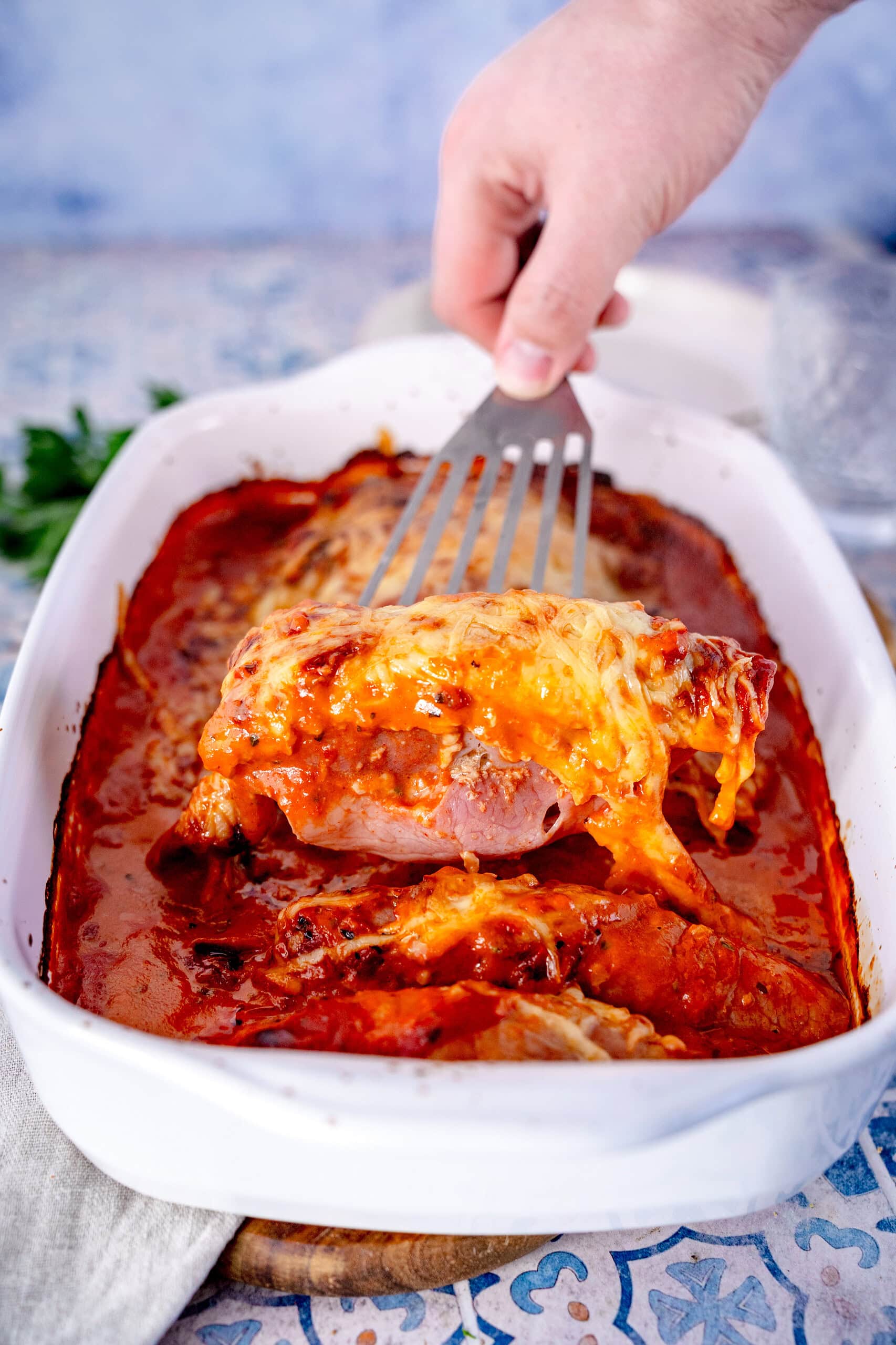 Schinken-Hack-Röllchen in einer Auflaufform mit Tomatensauce und Käse überbacken