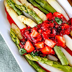 Erdbeer Chutney verteilt auf einem länglichen weißem Teller mit grünem und weißem Spargel