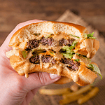 Big Mac in der Hand gehalten mit viel Big Mac Sauce