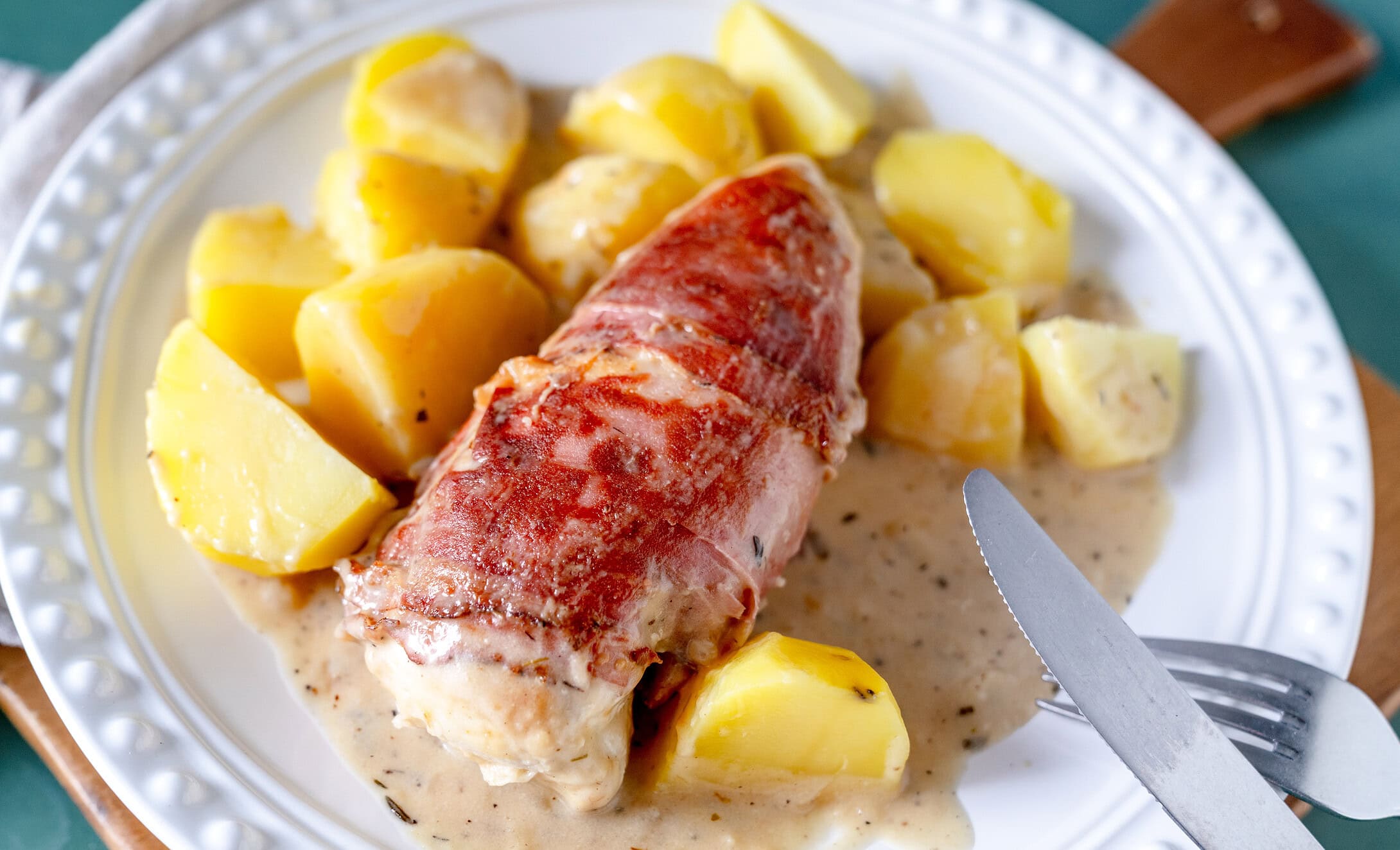 Hähnchen in Bacon auf Salzkartoffeln mit einer Parmesansauce