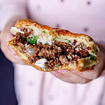 Angebissender Korean Sloppy Joeas mit Hackfleisch, Gurke und Mayo.
