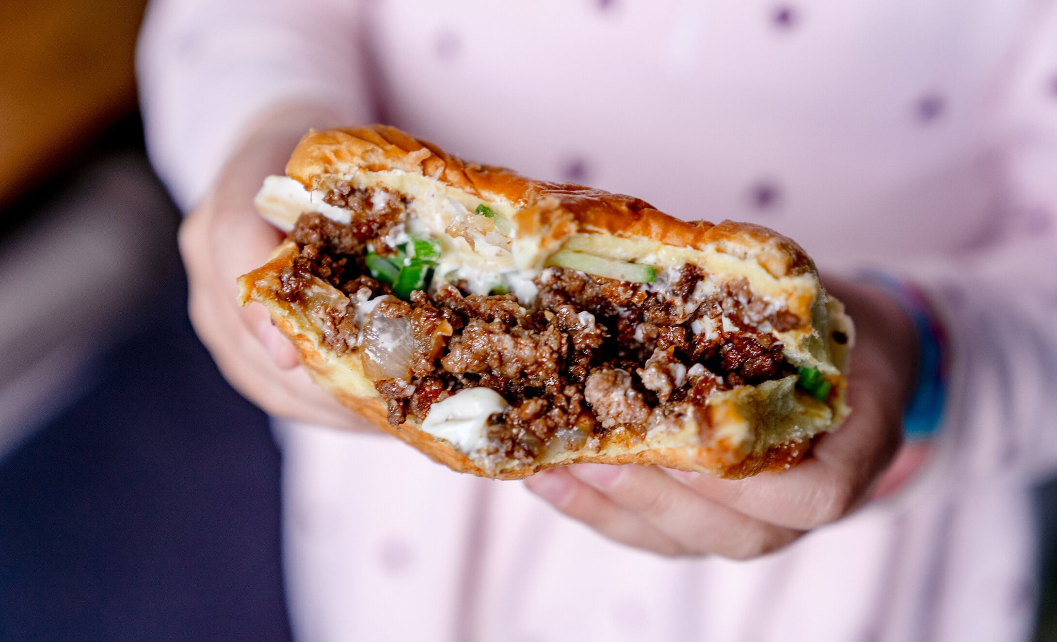 Angebissender Korean Sloppy Joeas mit Hackfleisch, Gurke und Mayo.